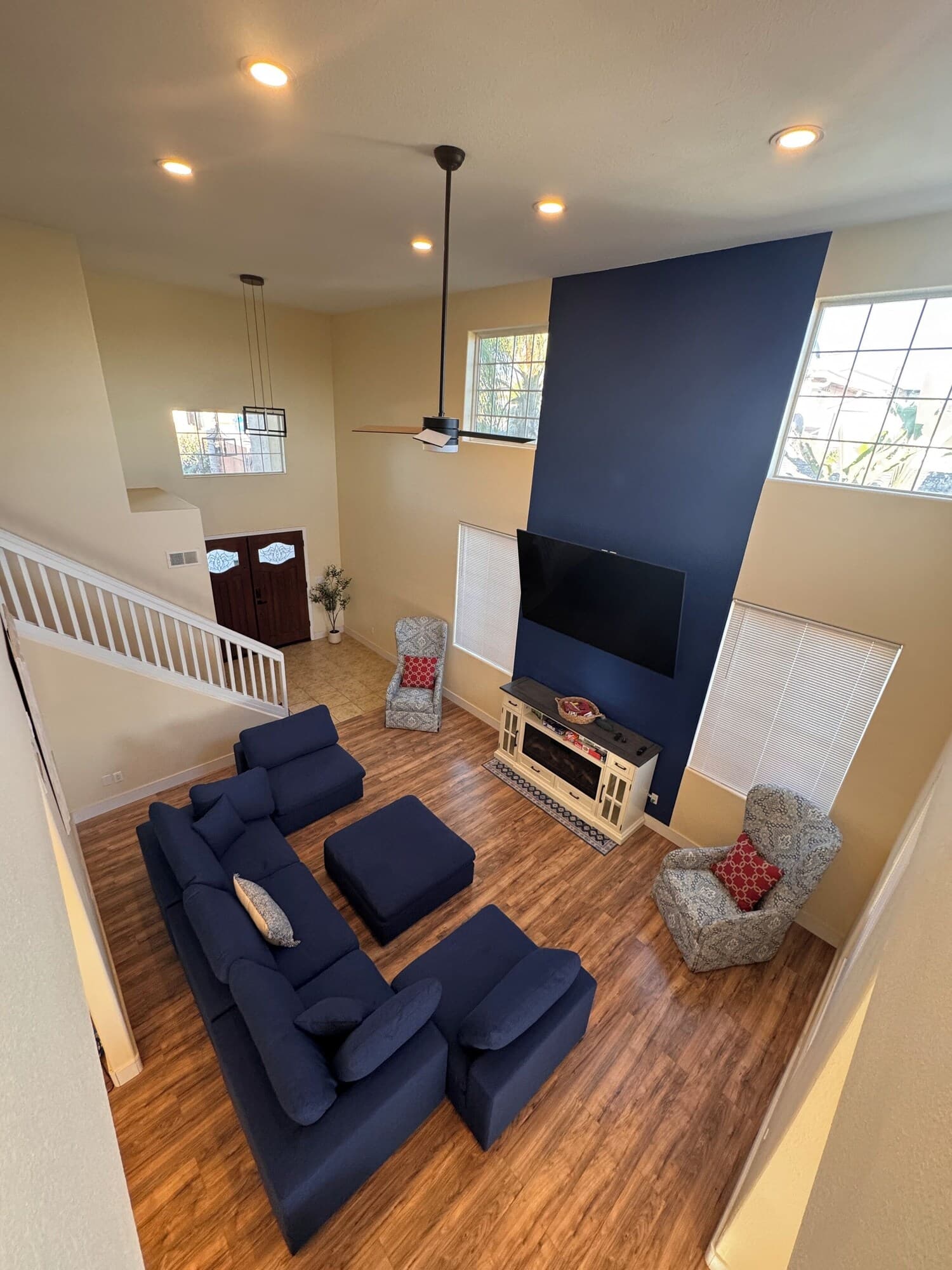 A spacious living room with a sectional sofa, a fireplace, and a large TV.