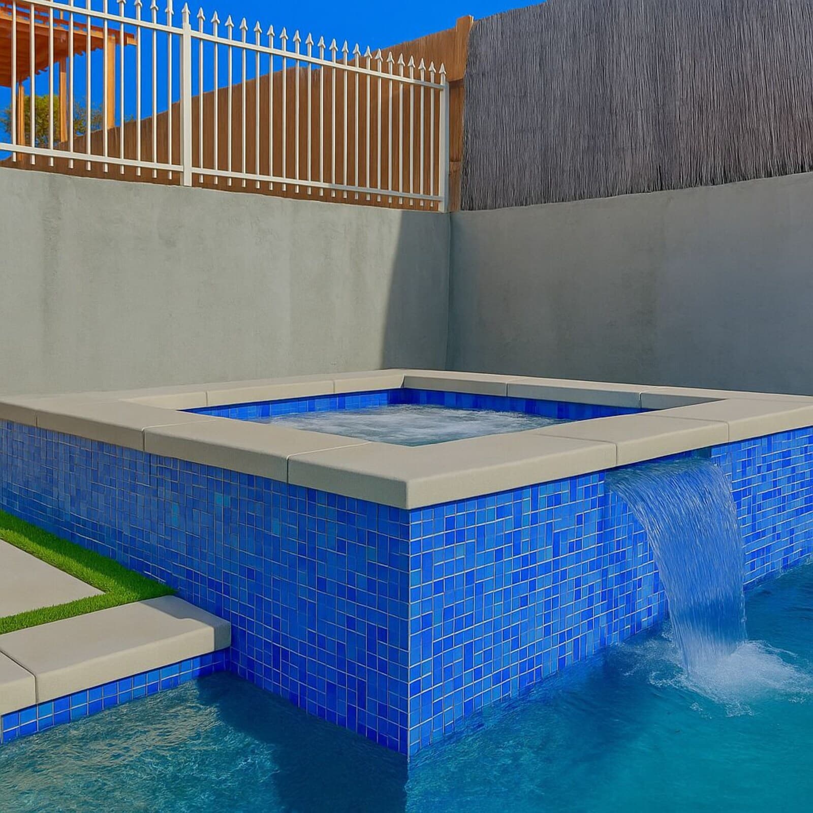 A swimming pool with blue tiles and a water feature.